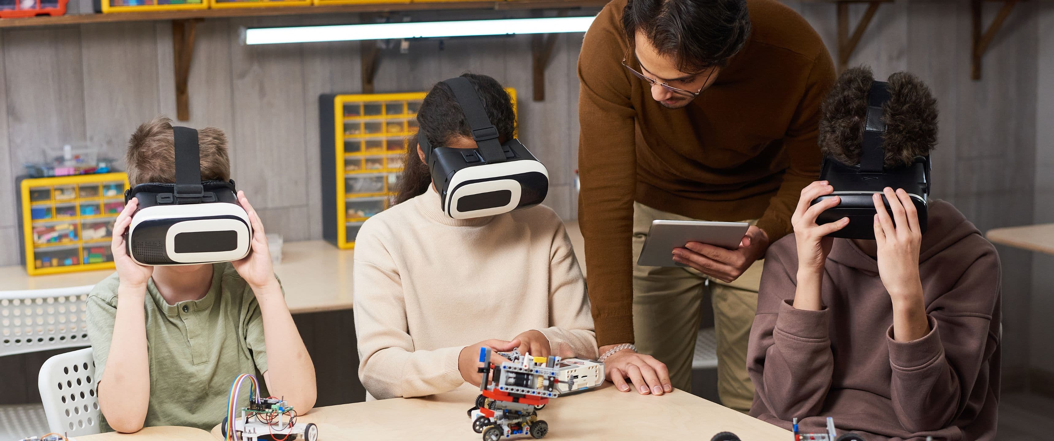 Professor que ajuda a uns estudiants amb realitat virtual