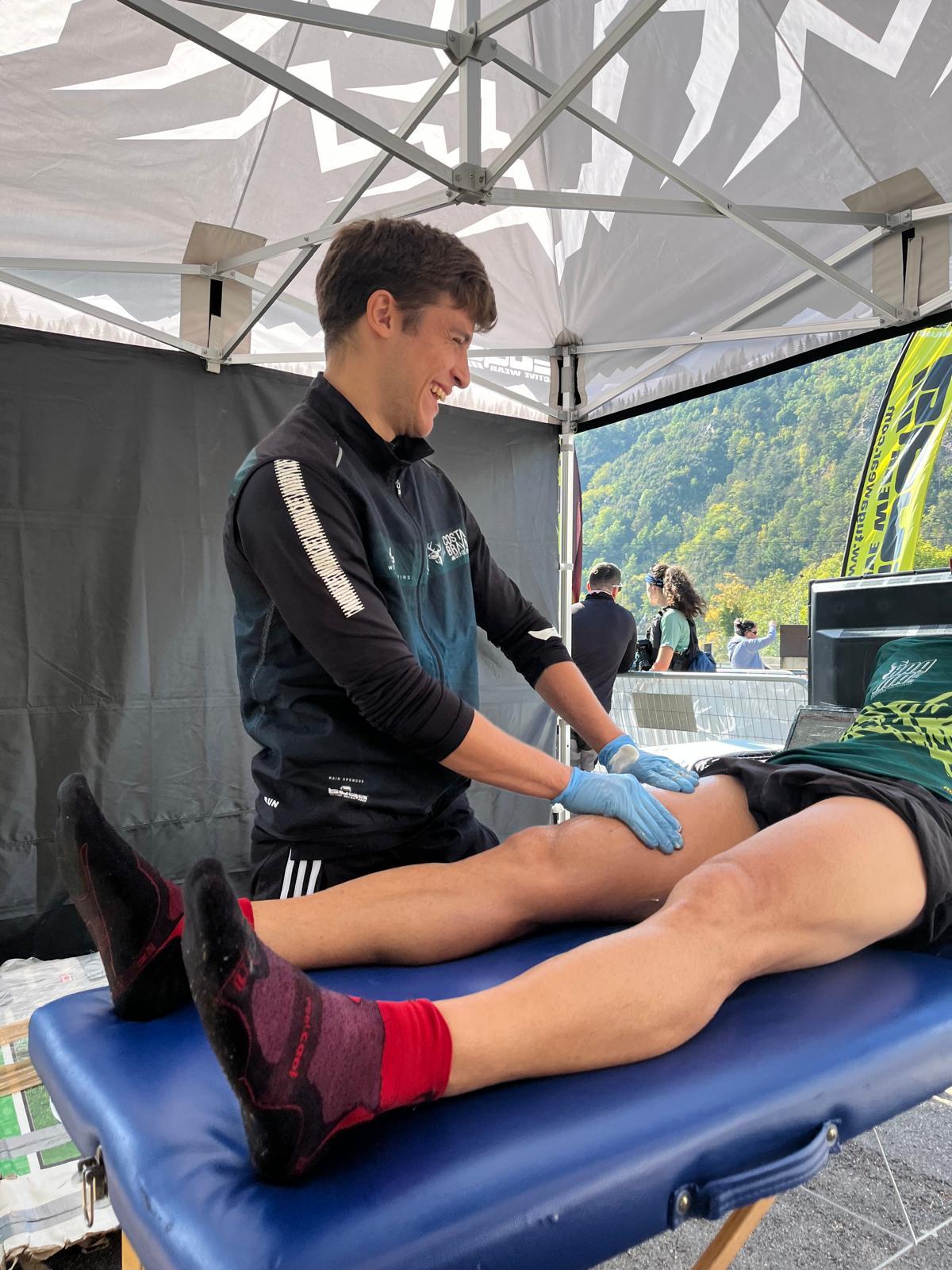 Alumne de fisioteràpia oferint un servei de massatge recuperador als corredor