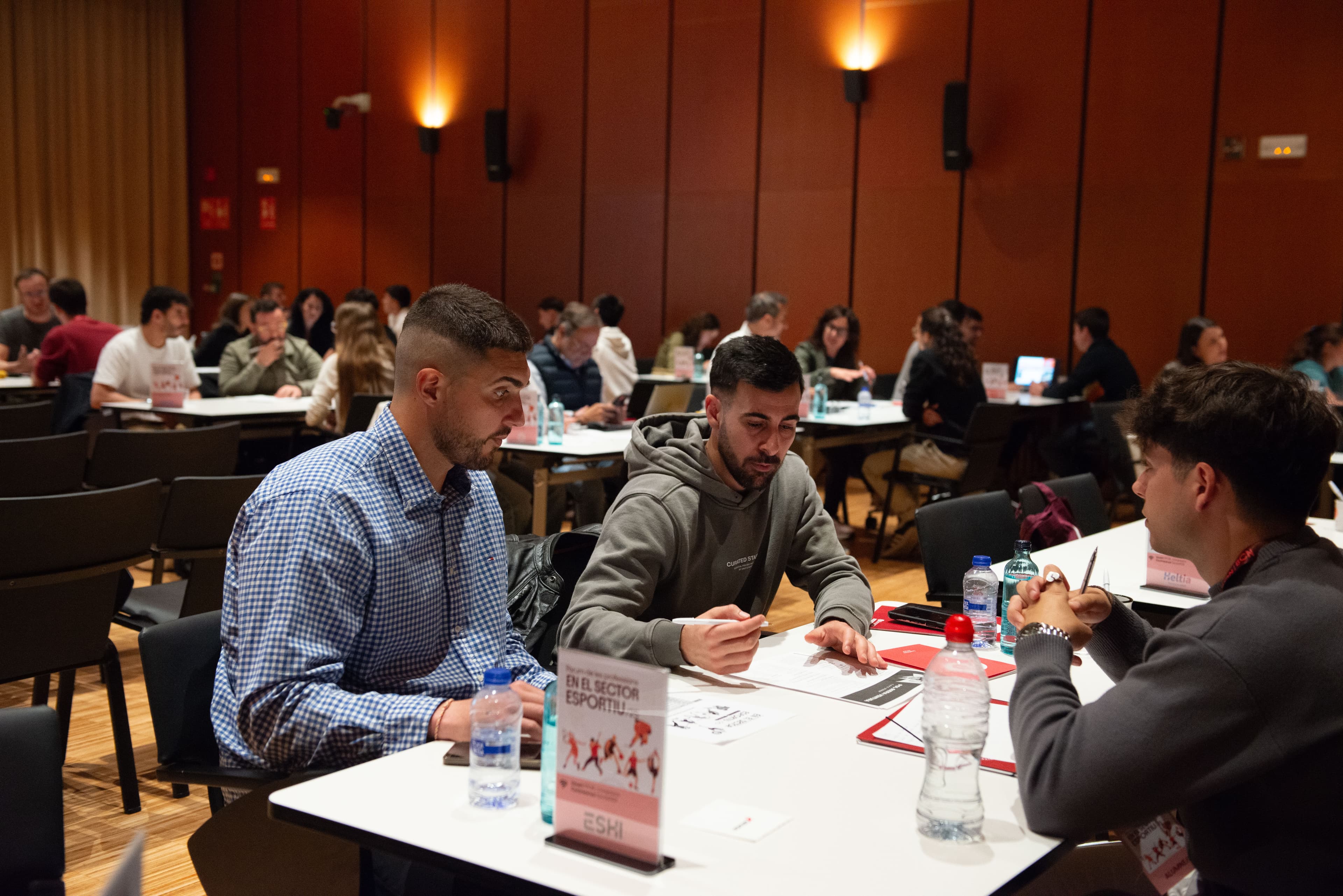 Taules amb ocupadors i estudiants d'esport a l'Auditori